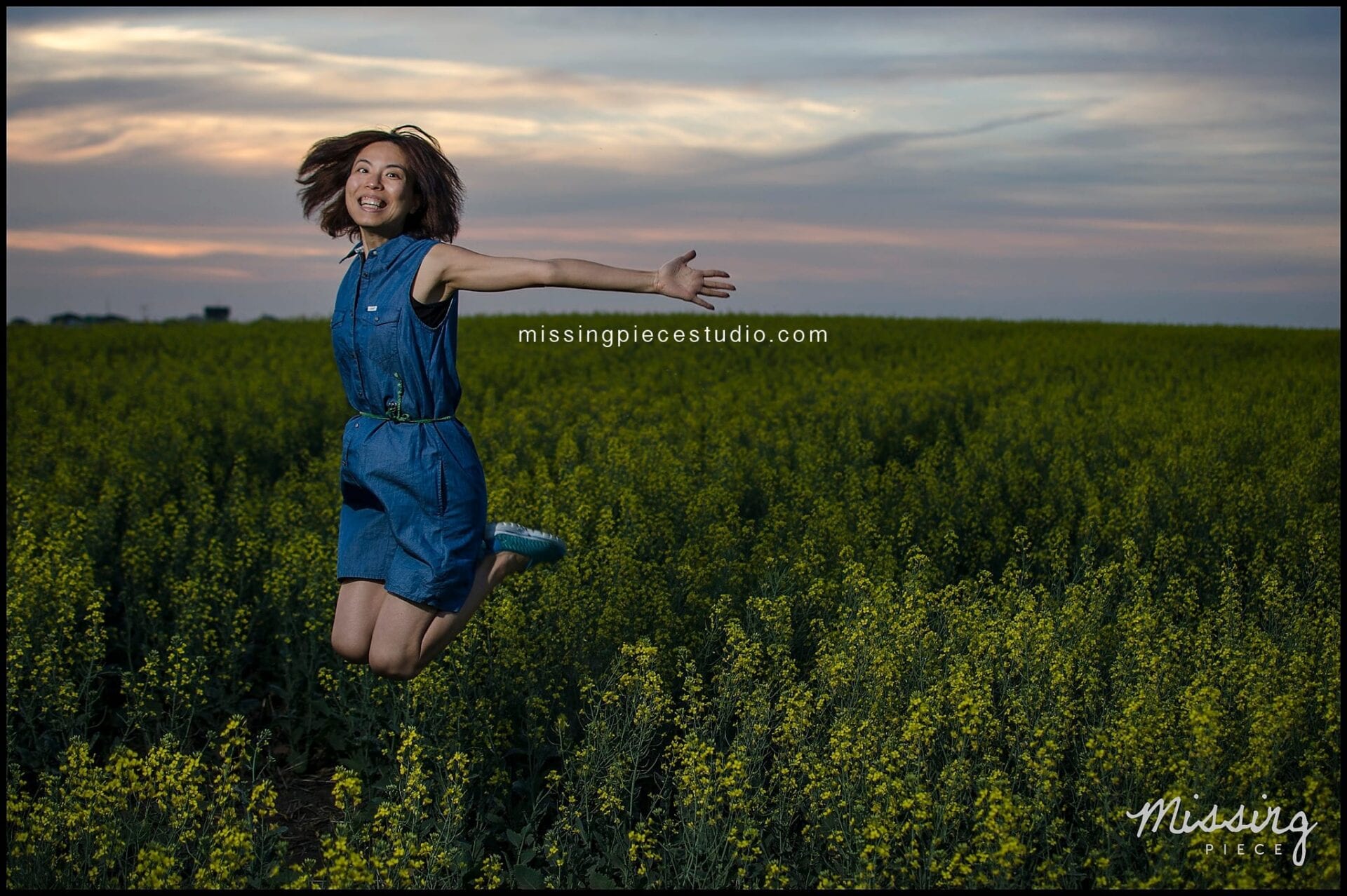 A girl jumping with joy in a beautiful canola field during sunset.